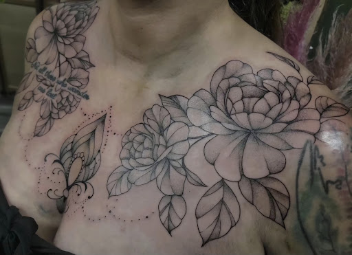 Find in between boob tattoo ideas for your next unique tattoo in Valdosta at Acid Ink Tattoos