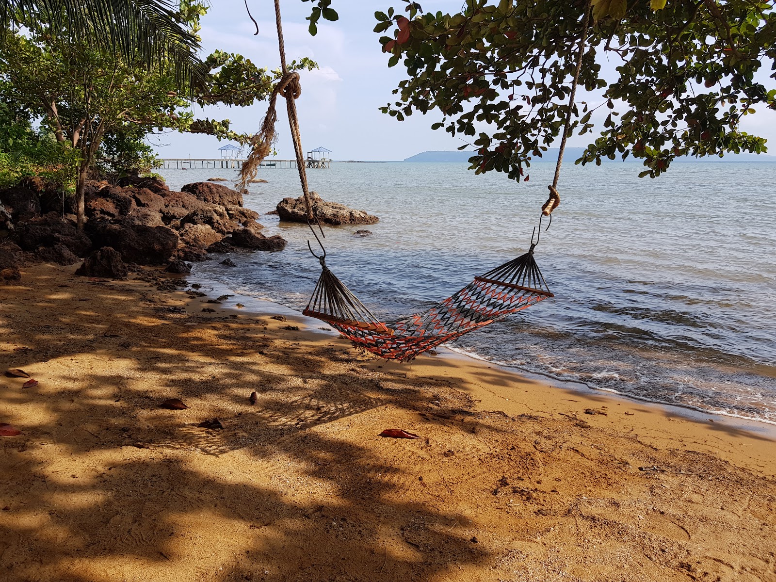 Φωτογραφία του Koh Mak Buri Hut Beach με καφέ άμμο και βράχια επιφάνεια