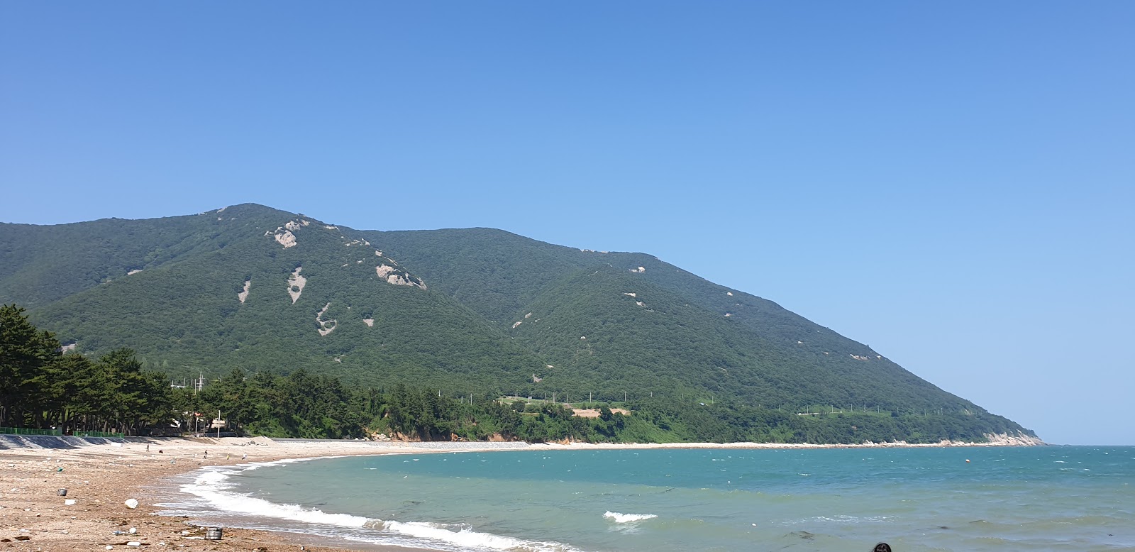 Foto van Geumjang Beach met zand met stenen oppervlakte