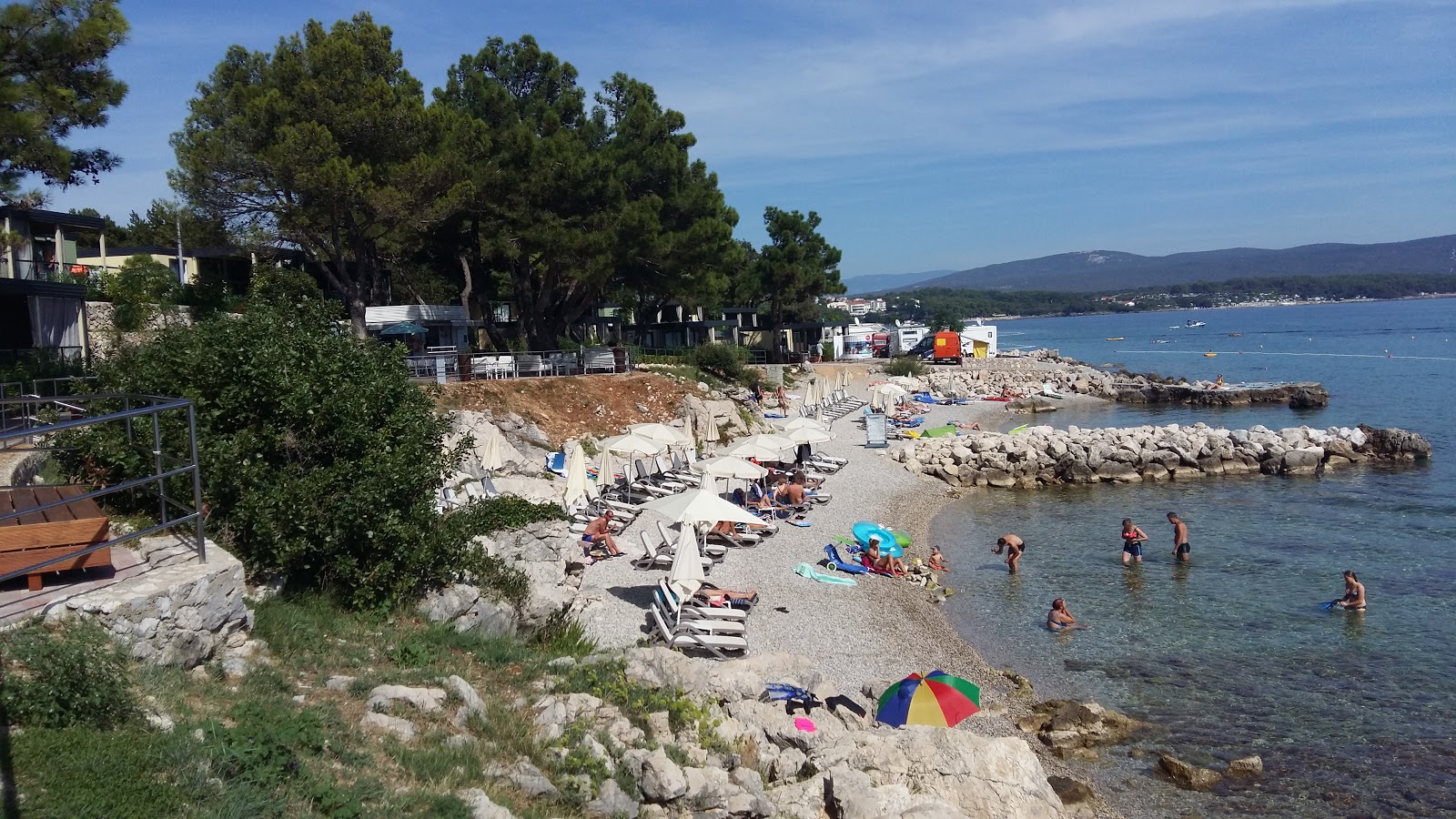 Foto di Karaka beach con una superficie del ciottolo fine bianco