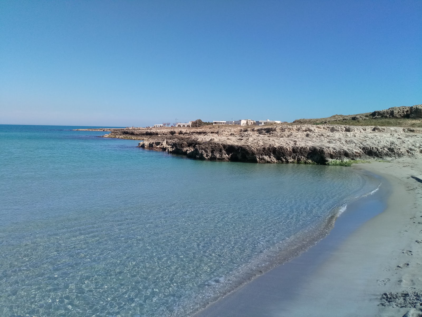 Fotografie cu Spiaggia Mezzaluna cu o suprafață de apă pură albastră