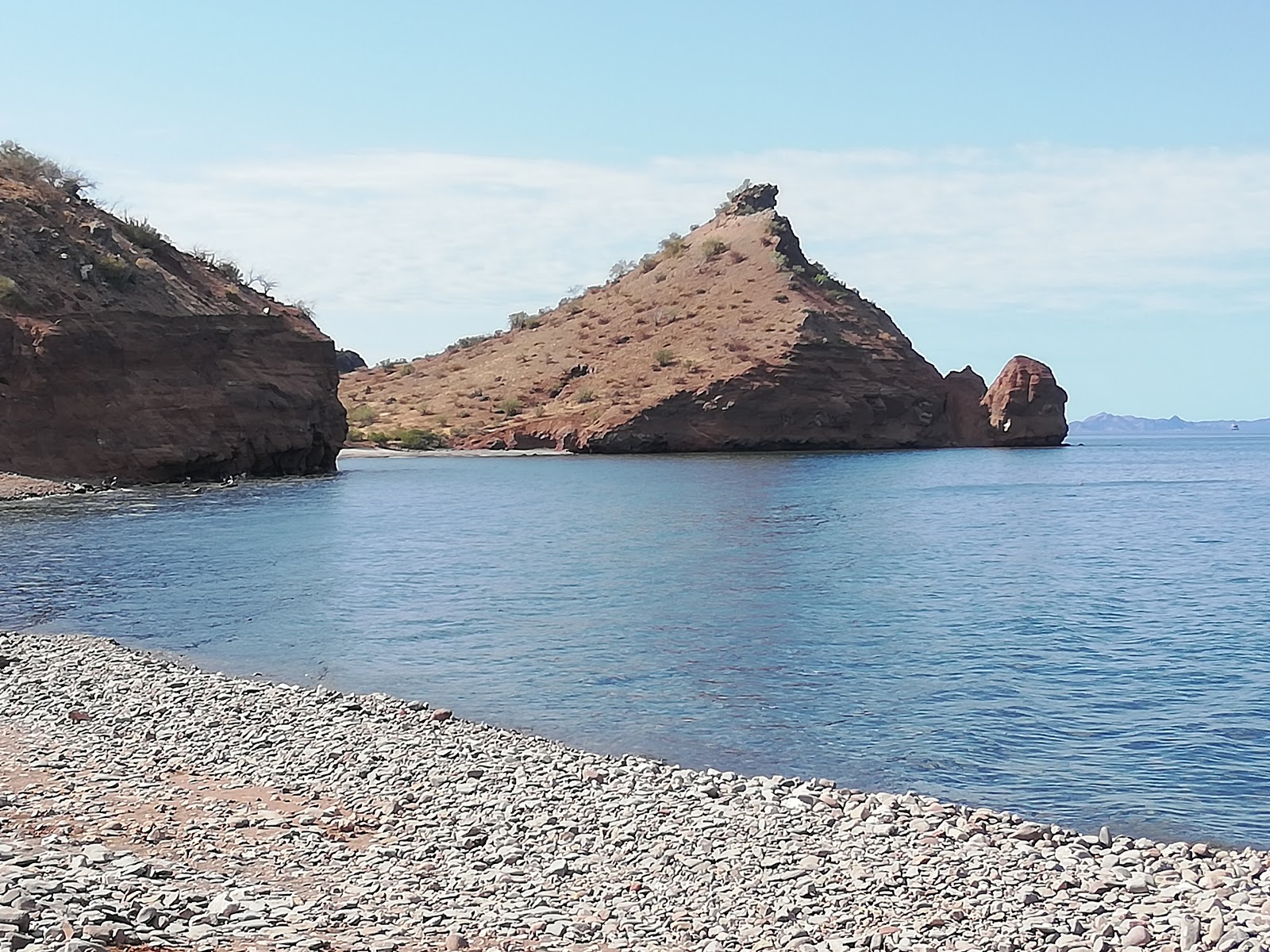 Playa San Cosme'in fotoğrafı gri çakıl taşı yüzey ile