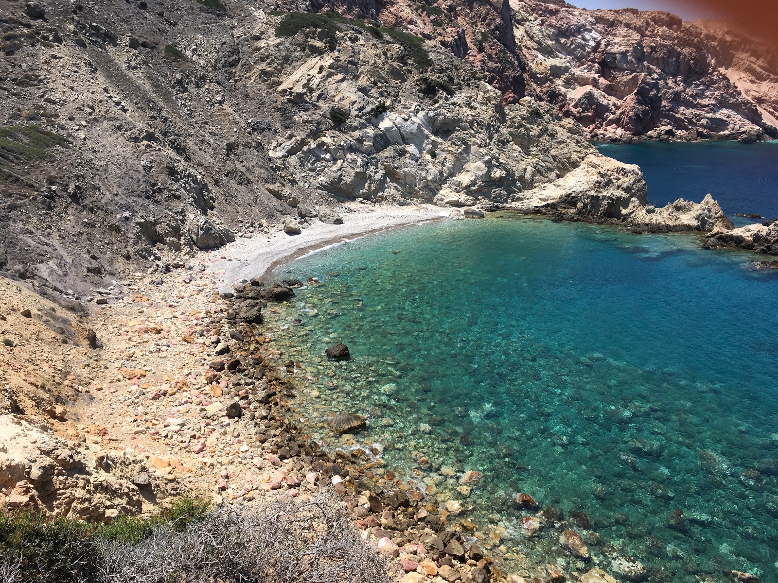 Foto di Ammoudi beach con una superficie del sabbia beige e rocce