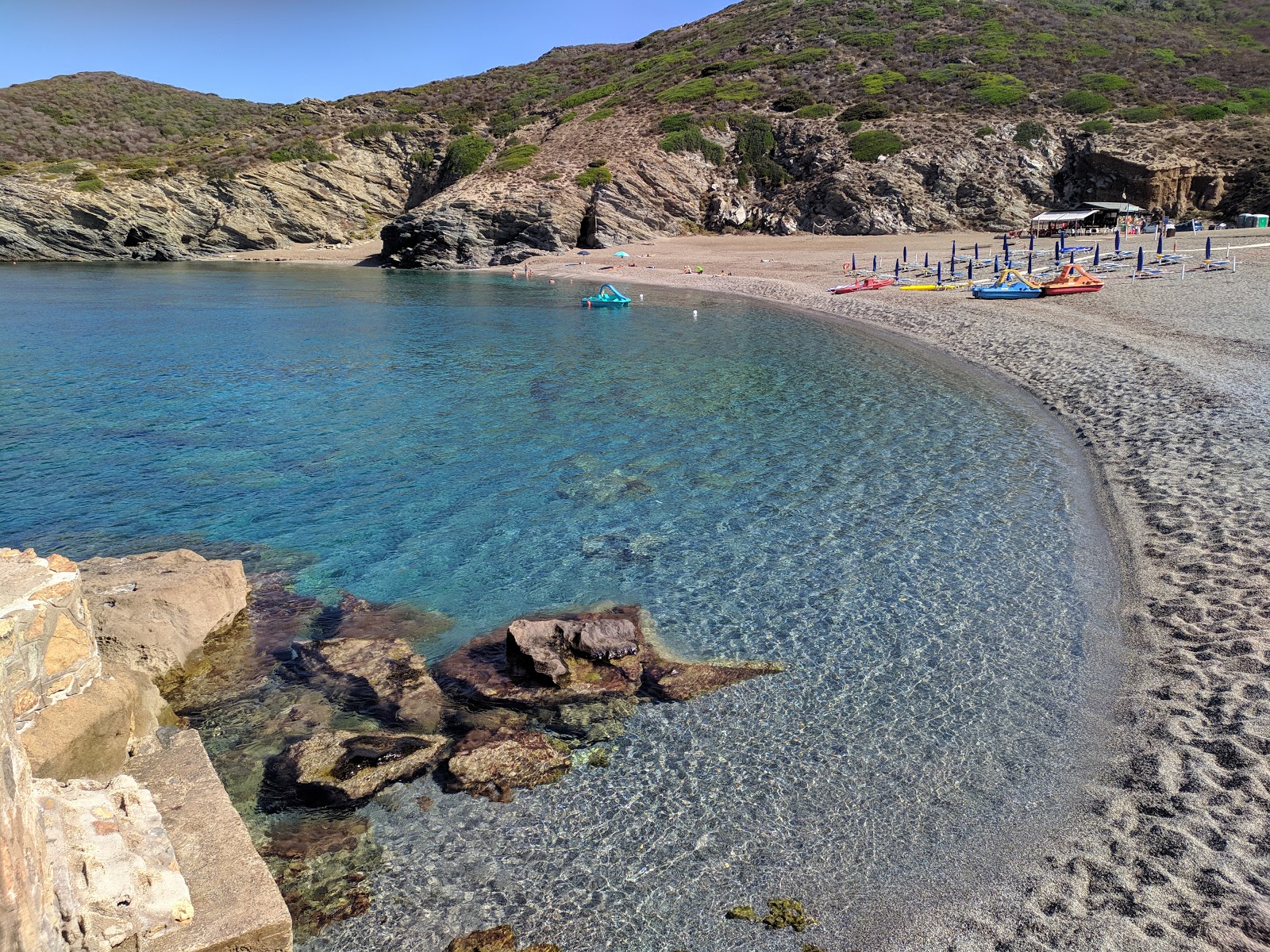 Photo of Cala dell'Argentiera with gray sand &  pebble surface