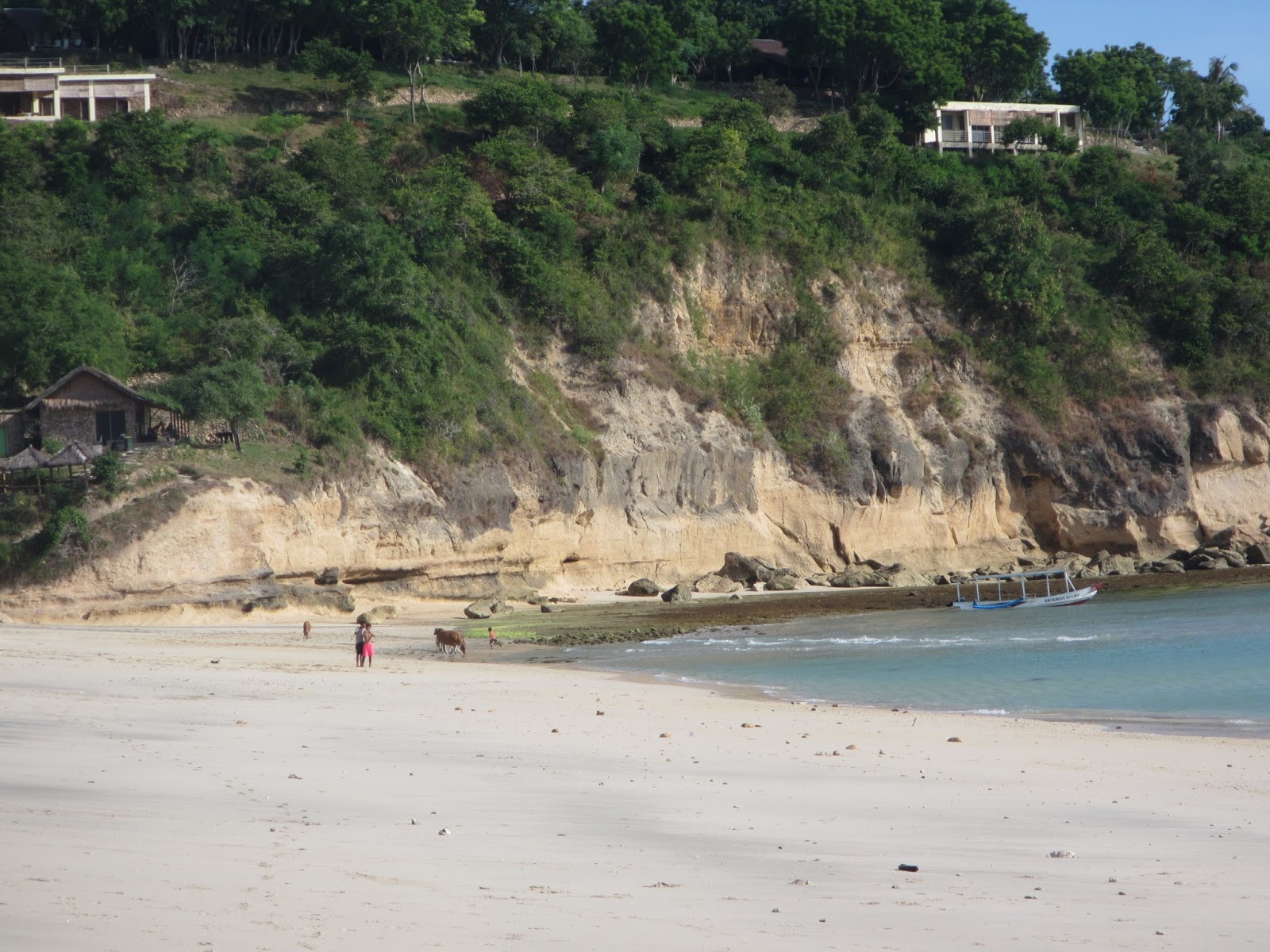 Foto von Rungkang Beach von Klippen umgeben