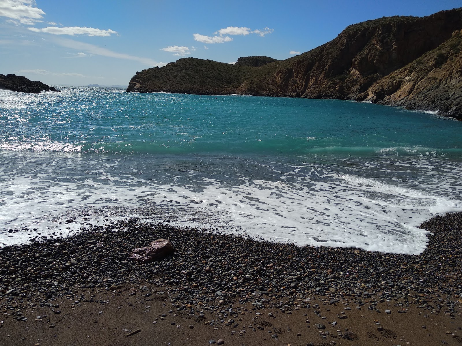 Foto von Playa Cala Cerrada umgeben von Bergen