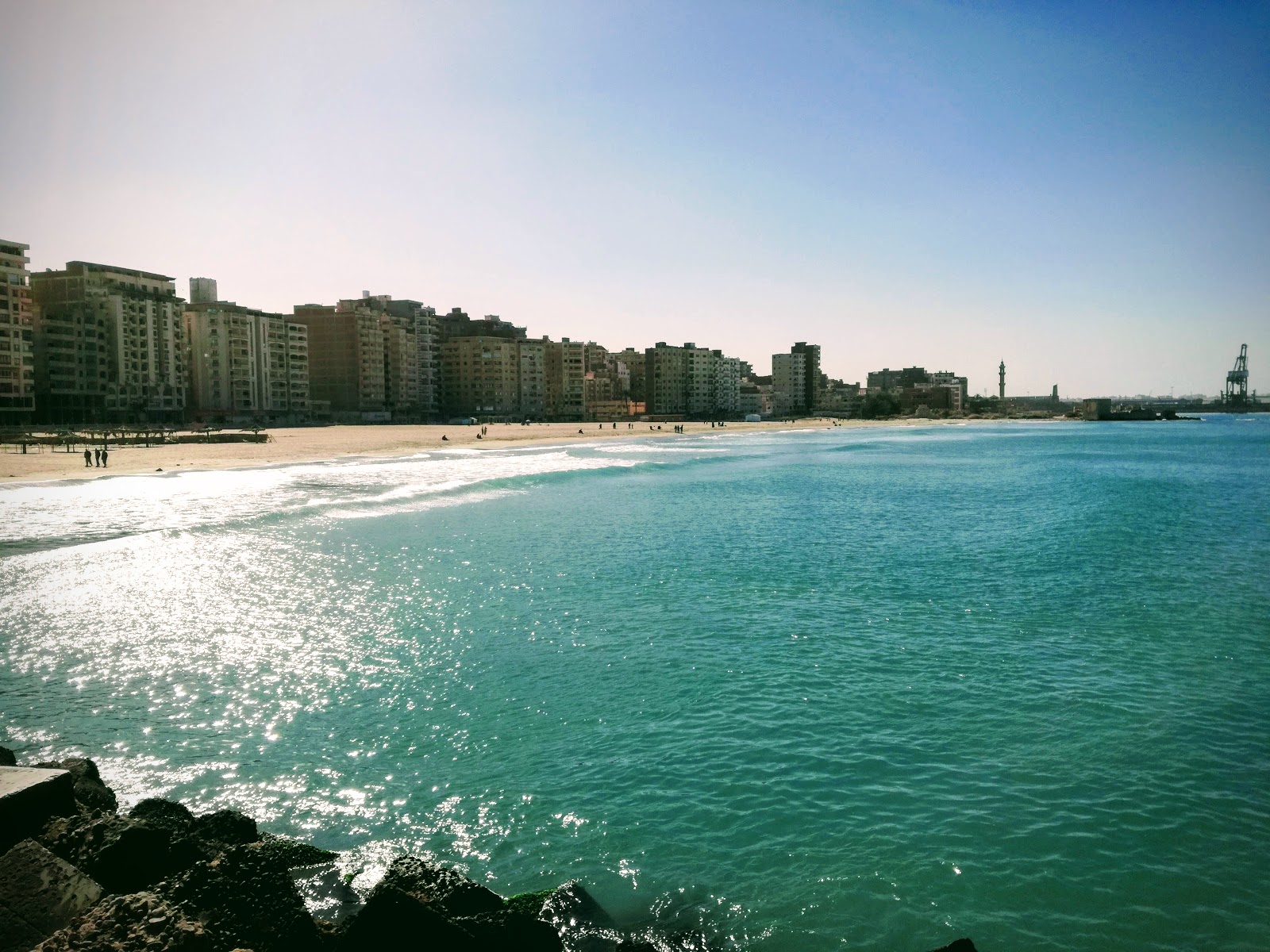 Foto av El Nakheel Free Beach med vit fin sand yta