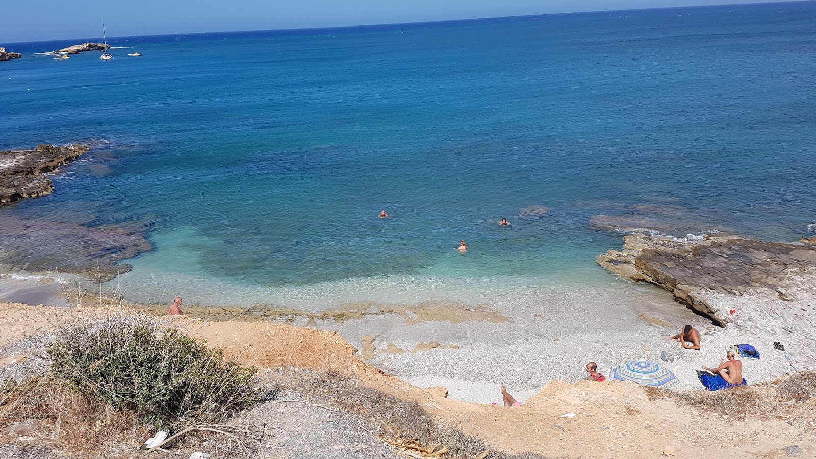 Foto van Unofficial FKK Naturist Beach met helder zand & rotsen oppervlakte