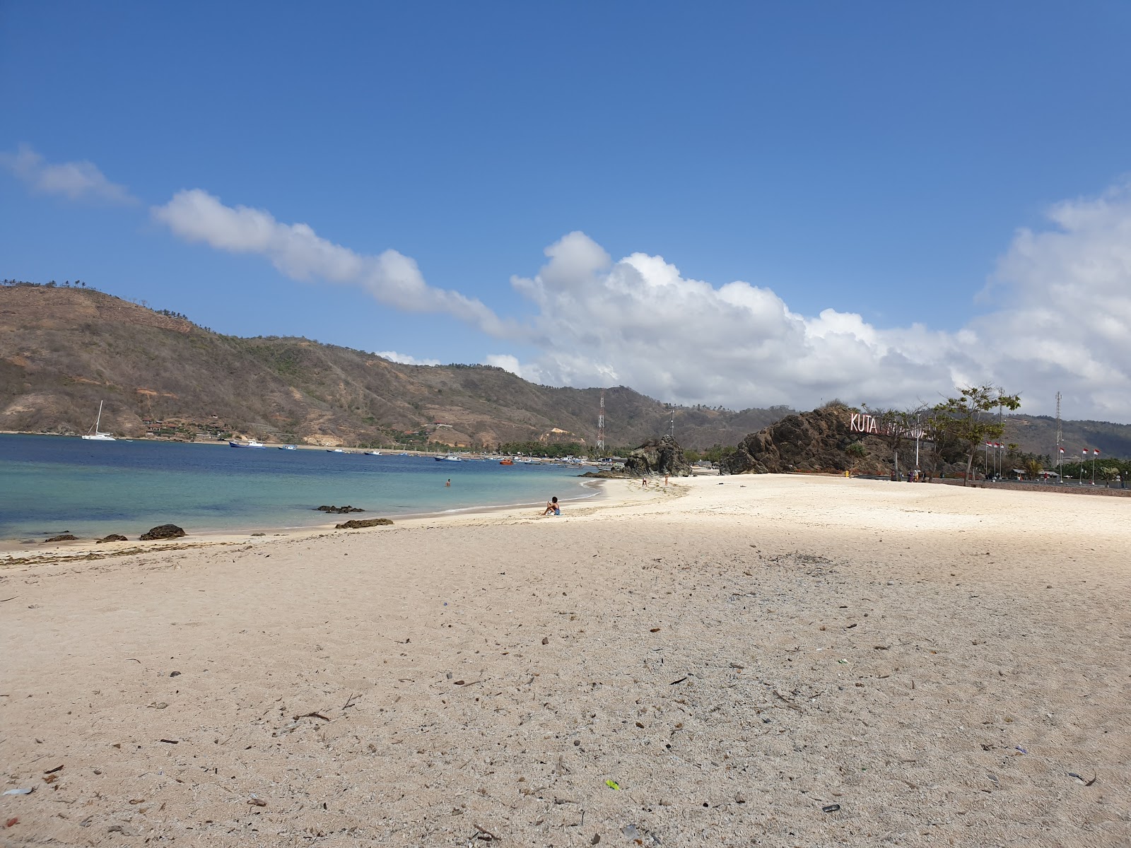 Foto av Kuta Mandalika Beach omgiven av klippor