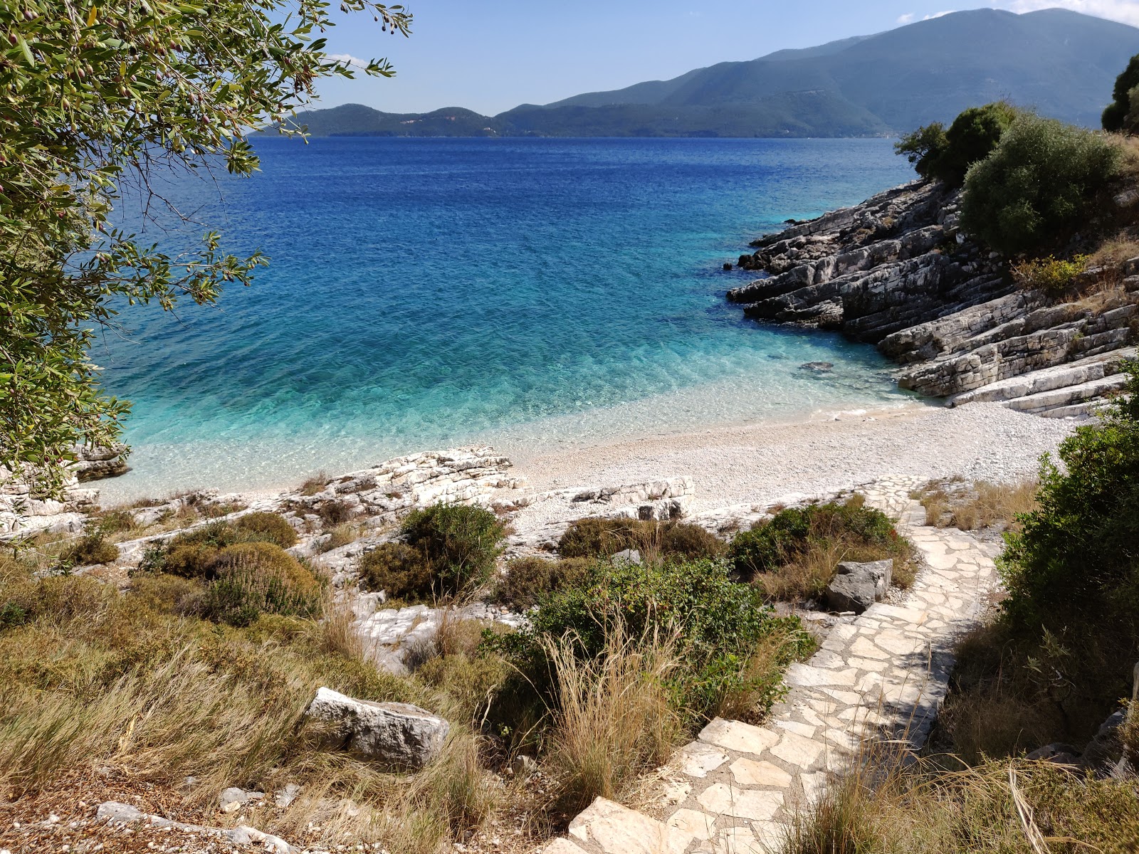 Φωτογραφία του Nici beach με μπεζ βότσαλα επιφάνεια