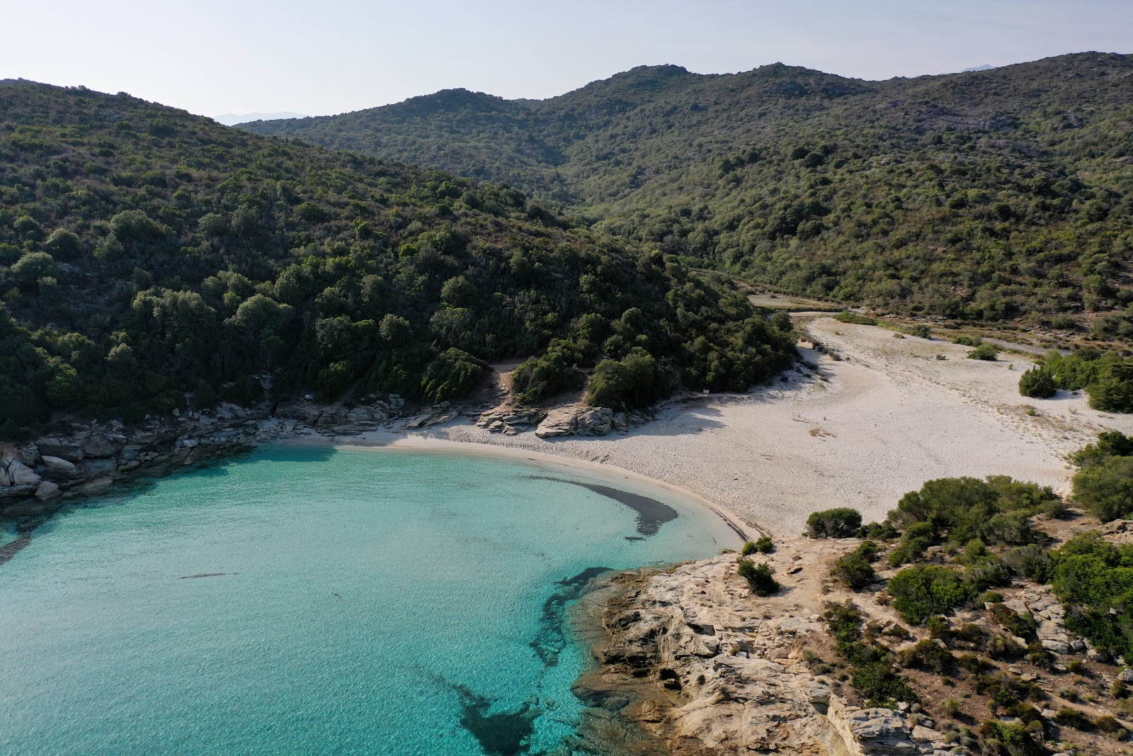 Foto di Petit Loto beach sorretto da scogliere