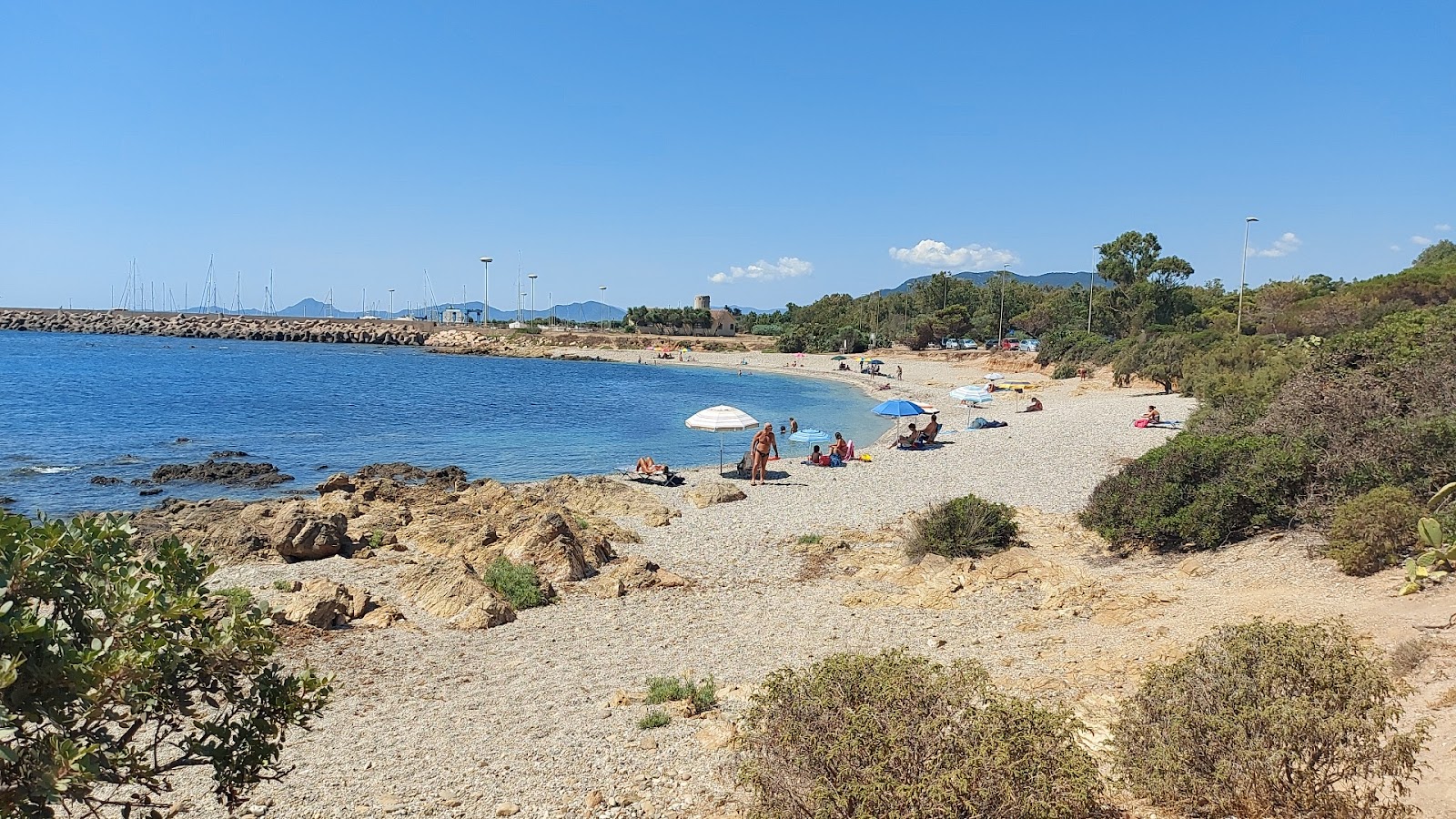 Foto av Spiaggia di Porto Corallino med lätt fin sten yta