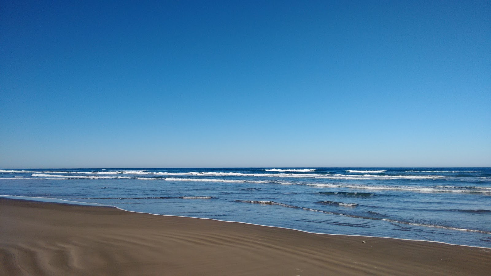 Praia de Arroio do Silva的照片 带有明亮的细沙表面