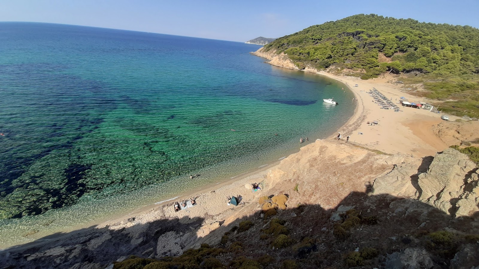 Foto av Mandraki beach med grå sand yta