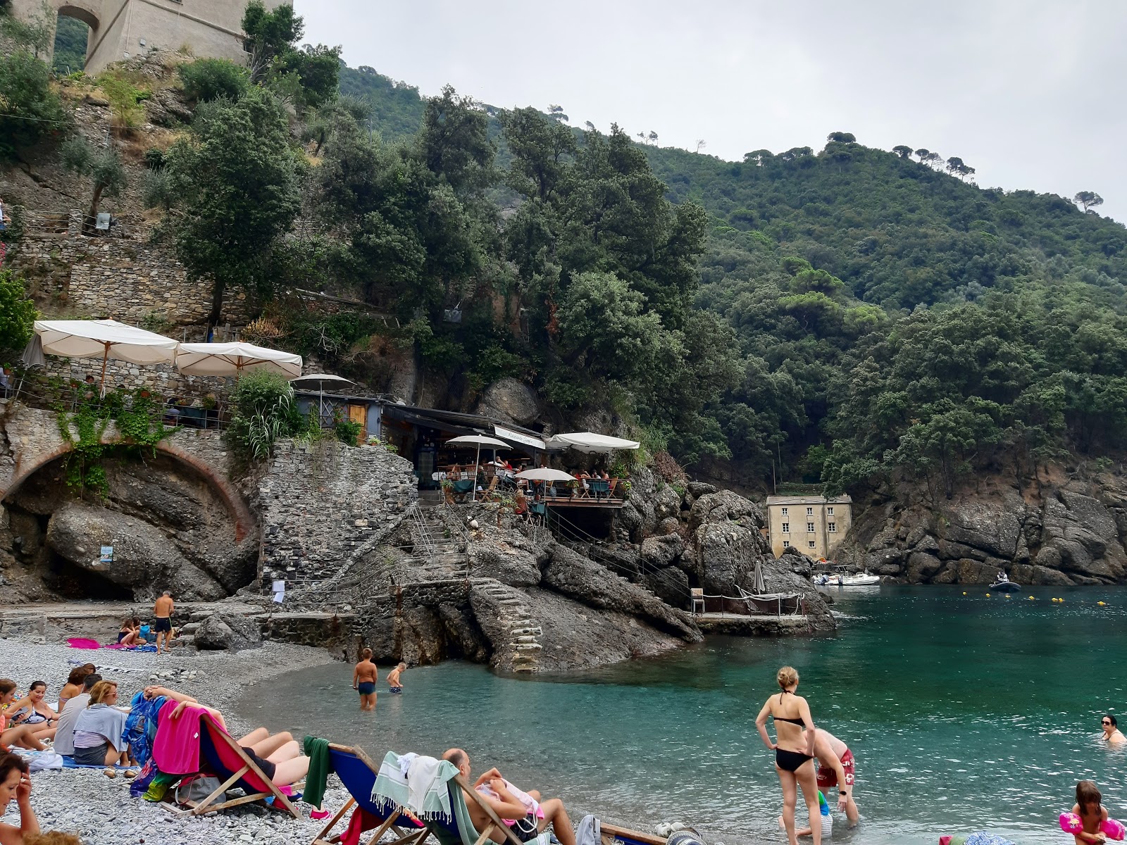Foto av Spiaggia San Fruttuoso omgiven av klippor