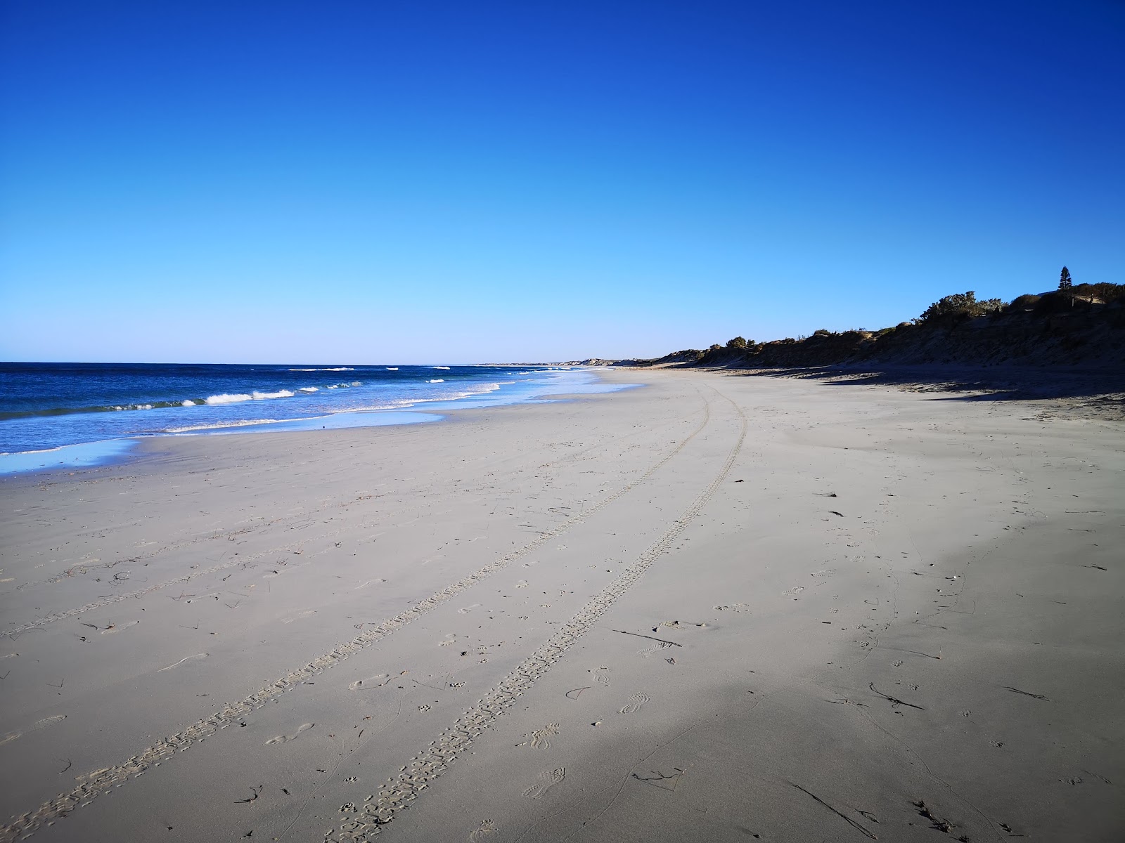 Fotografija Sunset Beach z svetel pesek površino