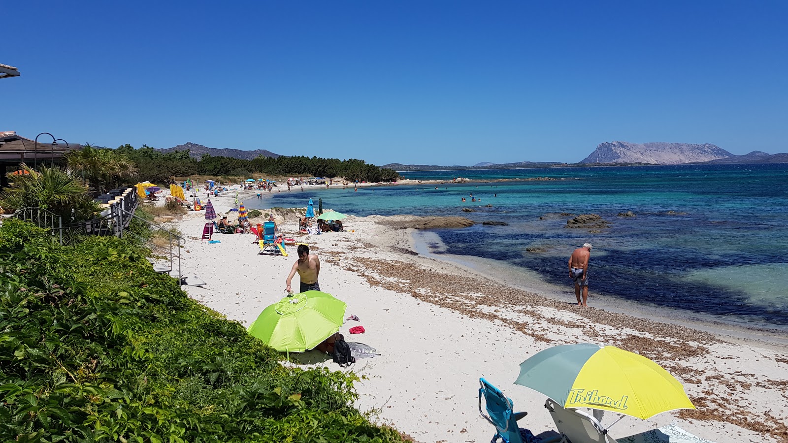 Foto av Spiaggia Cala d'Ambra med beige sand och småsten yta