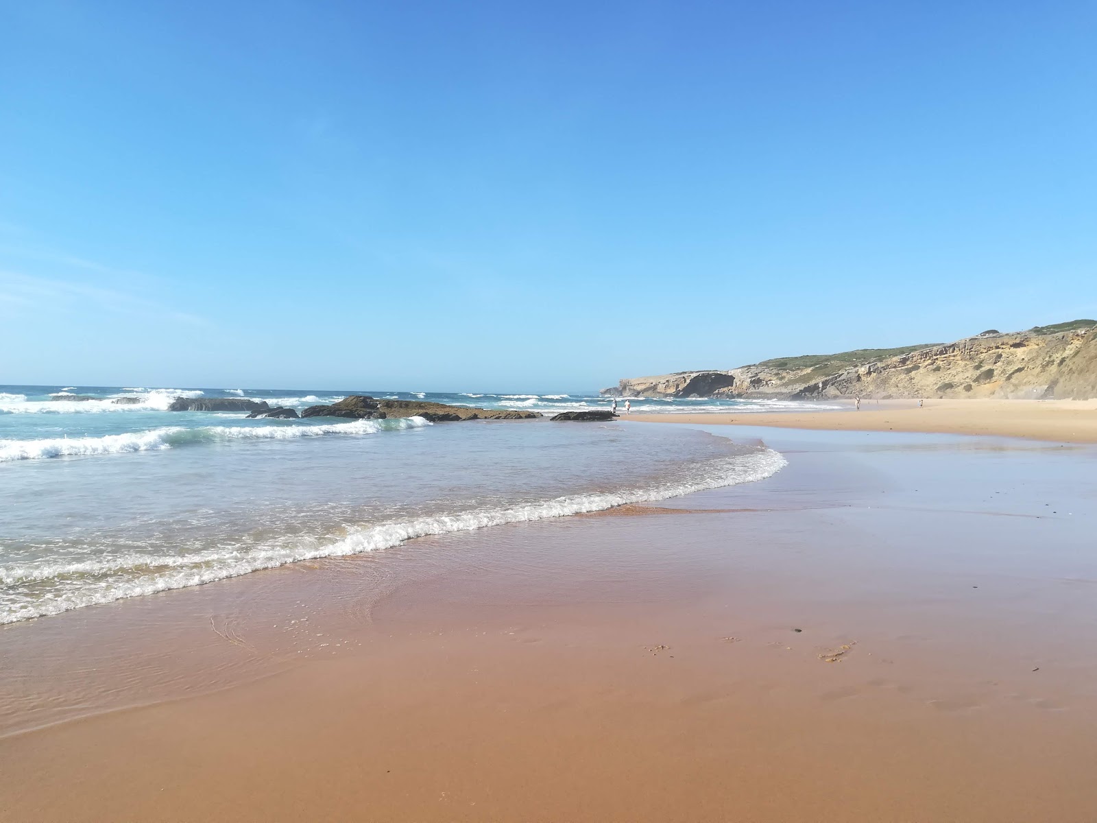 Photo de Praia de Monte Clerigo avec l'eau cristalline de surface