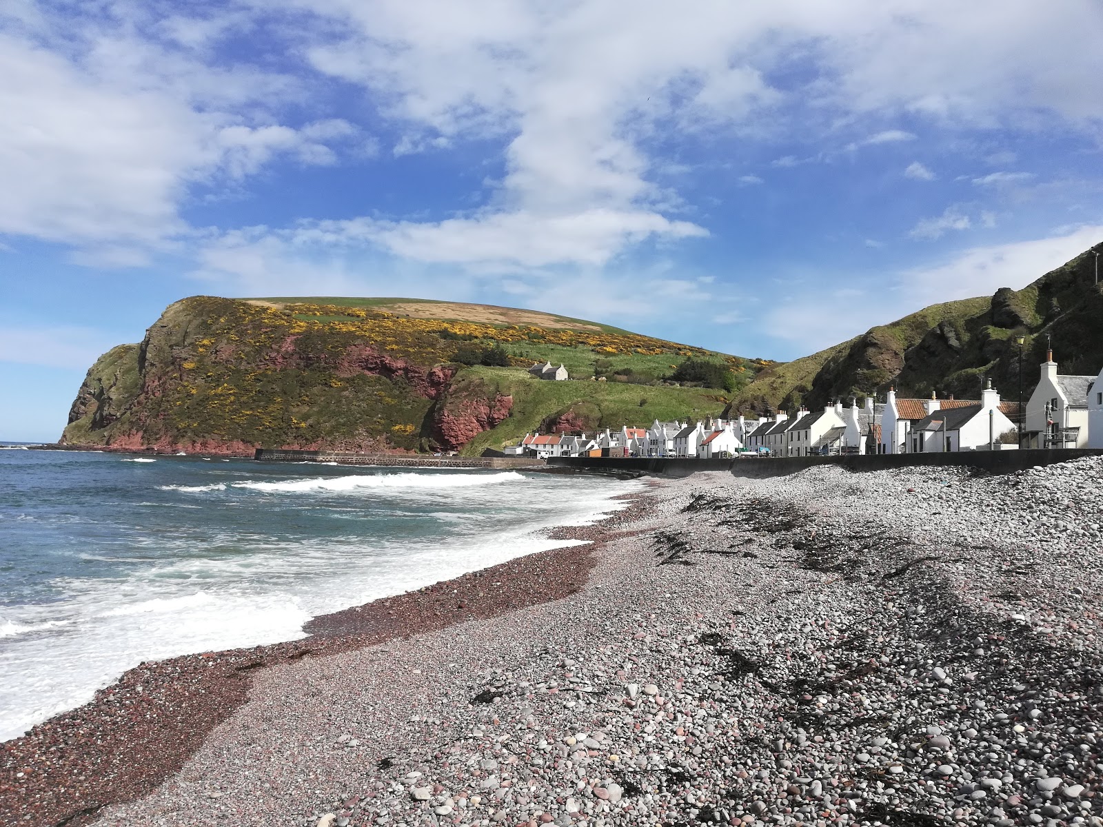 Photo of Pennan Bay Beach with gray pebble surface