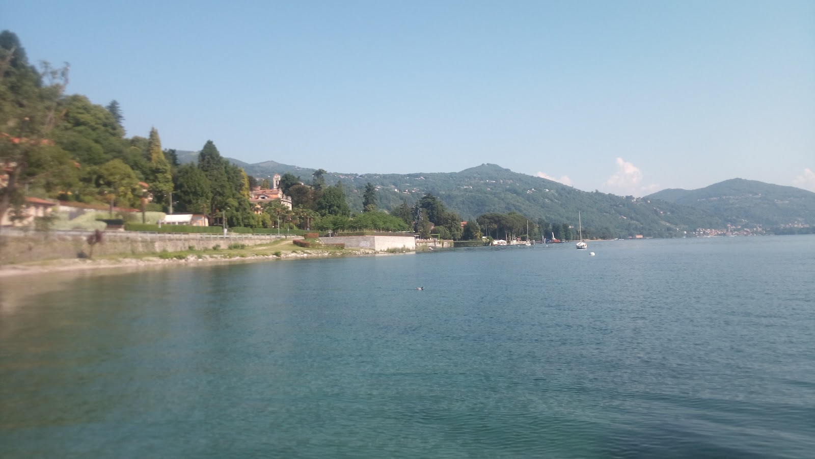 Spiaggia sul lago Maggiore的照片 带有碧绿色纯水表面
