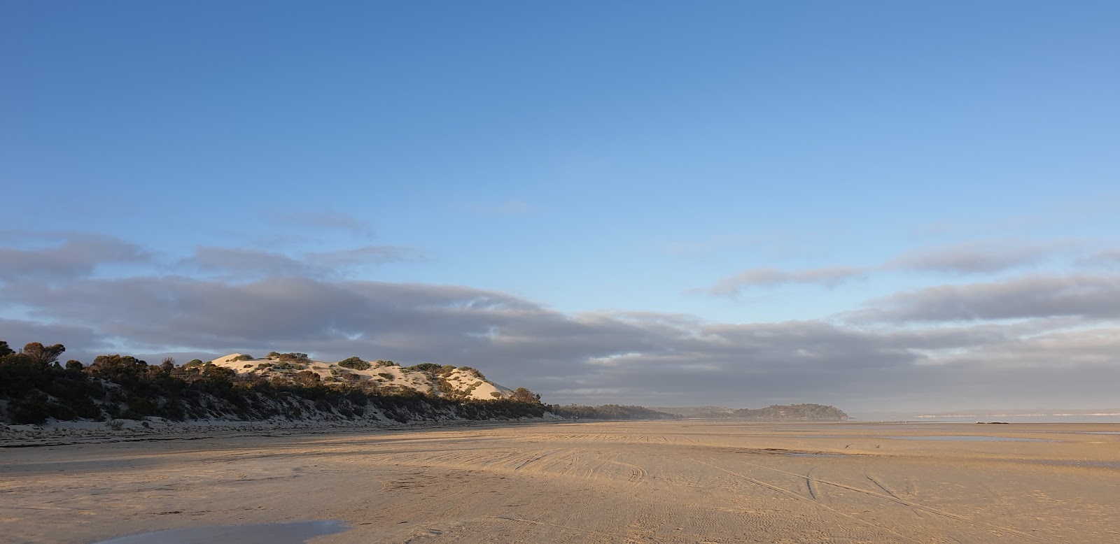 Foto av Farm Beach omgiven av berg