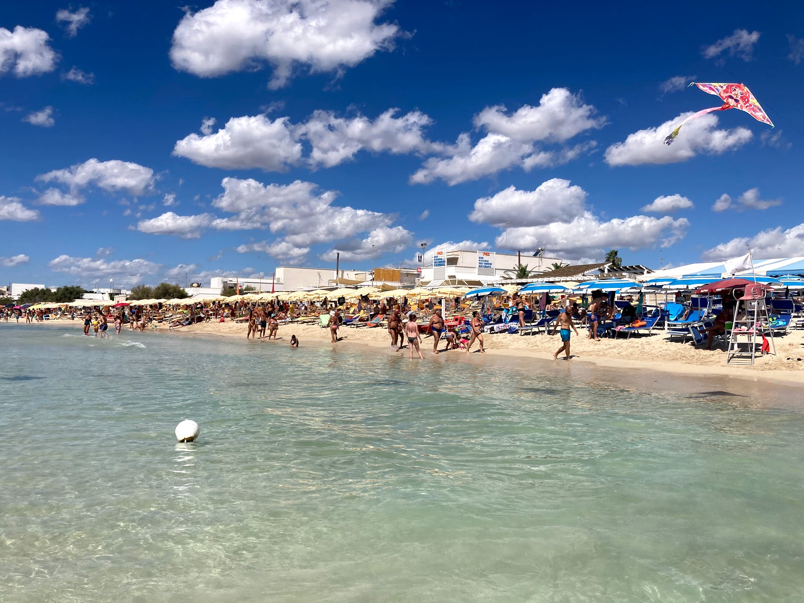 Valokuva Spiaggia di Torre Lapilloista. pinnalla sininen puhdas vesi:n kanssa