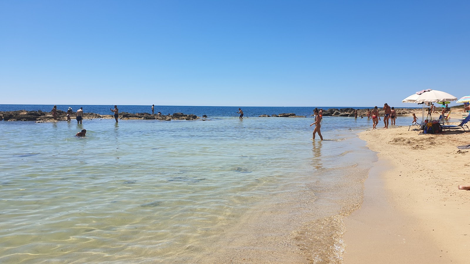 Spiaggia calette di salve的照片 带有蓝色纯水表面