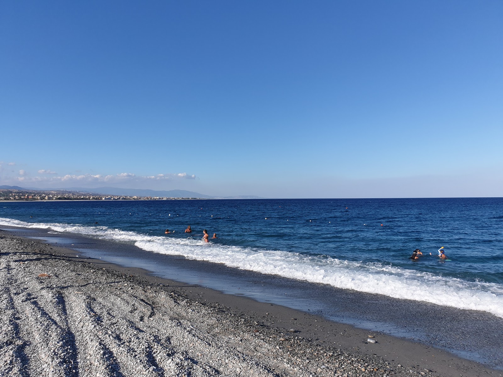 Foto av Costa Dei Gelsomini med blått vatten yta
