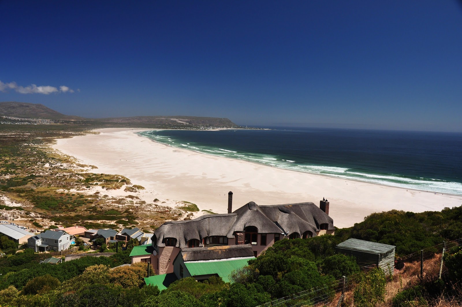 Foto von Noordhoek Beach von Klippen umgeben