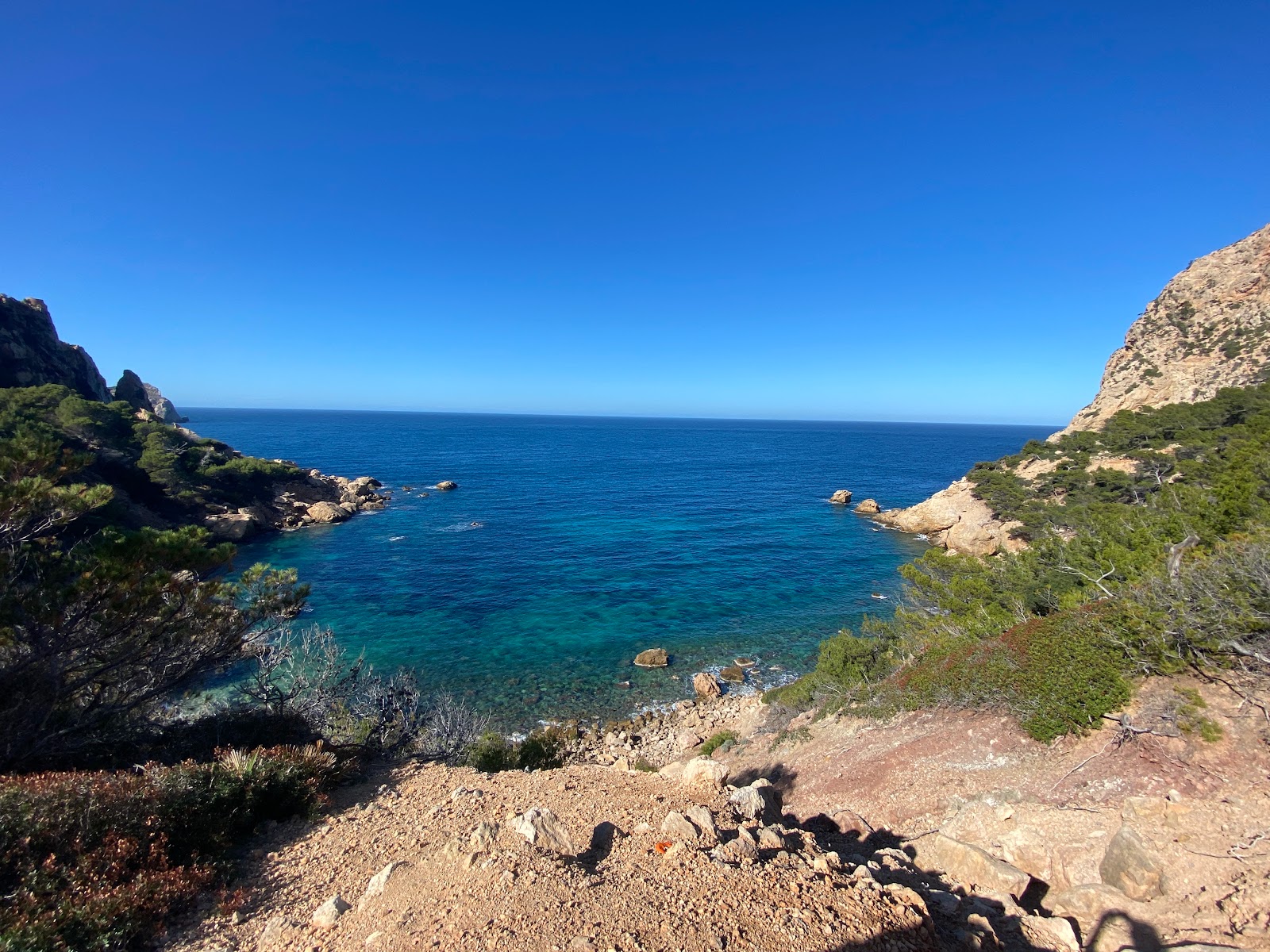 Photo of Cala en Basset backed by cliffs
