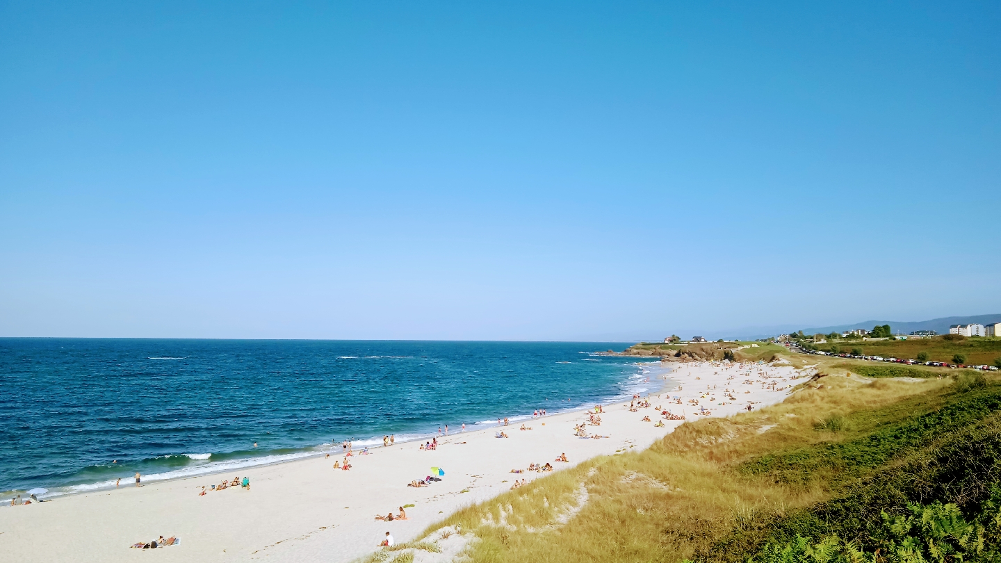 Photo de Llas Beach avec rivage droit, long
