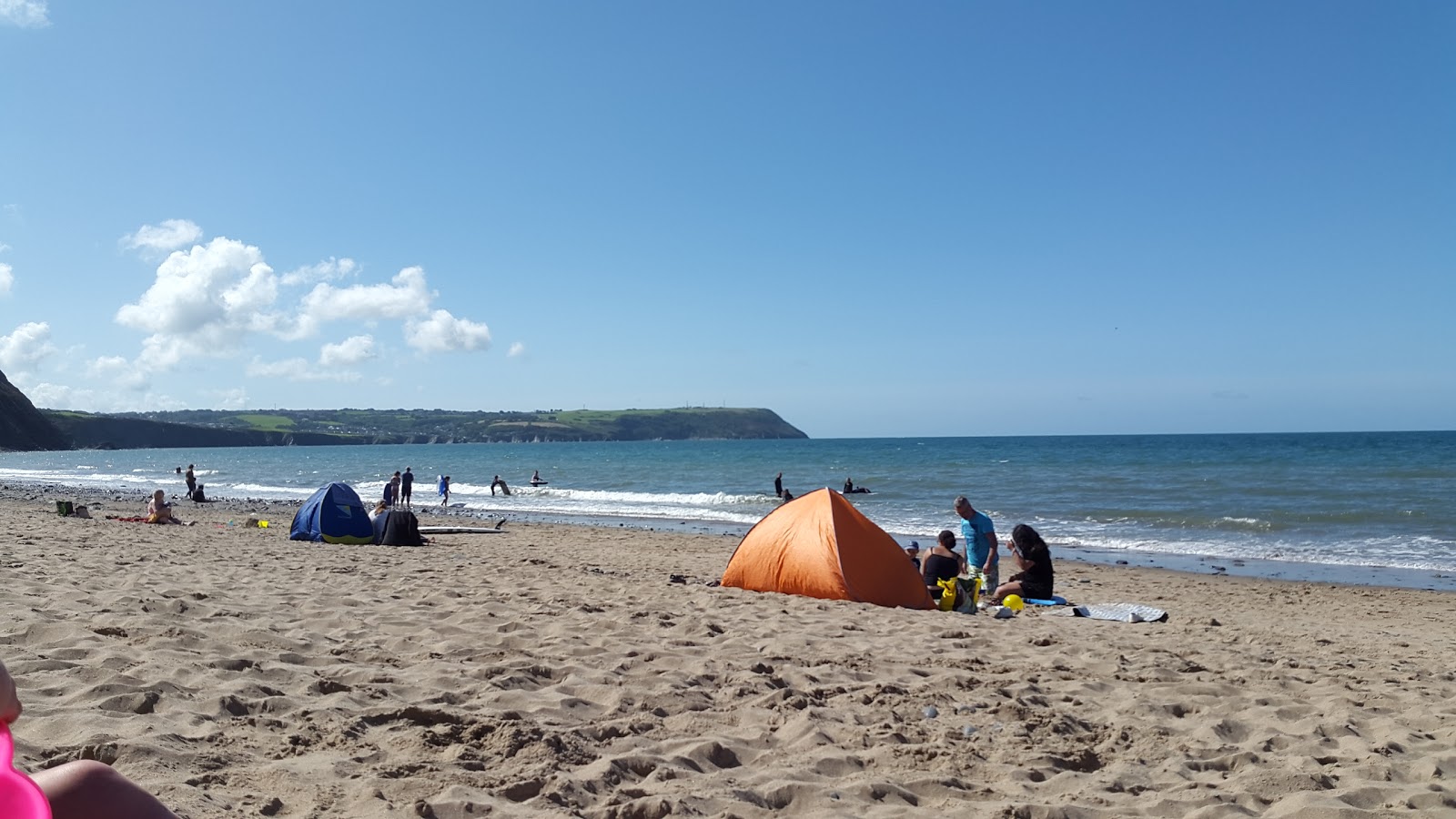 Foto von Penbryn Strand umgeben von Bergen