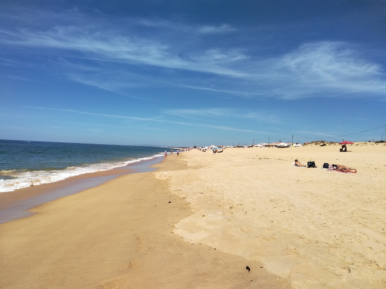 Foto av Faro strand med fin brun sand yta