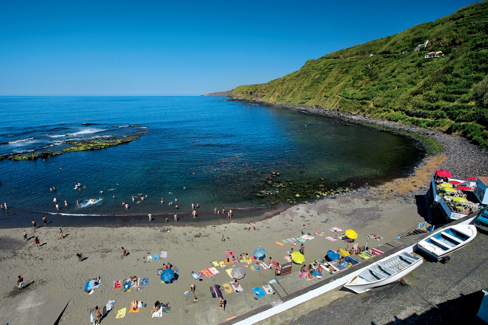 Foto de Praia do Calhau da Maia com areia cinza e pedras superfície