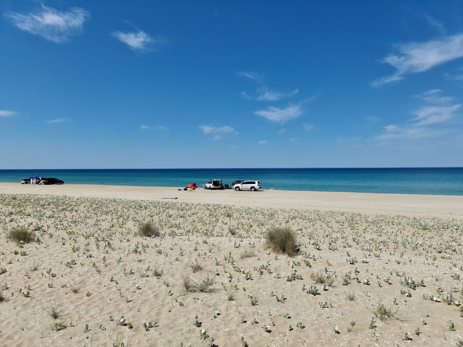 Valokuva Alau beachista. pinnalla kirkas hiekka:n kanssa