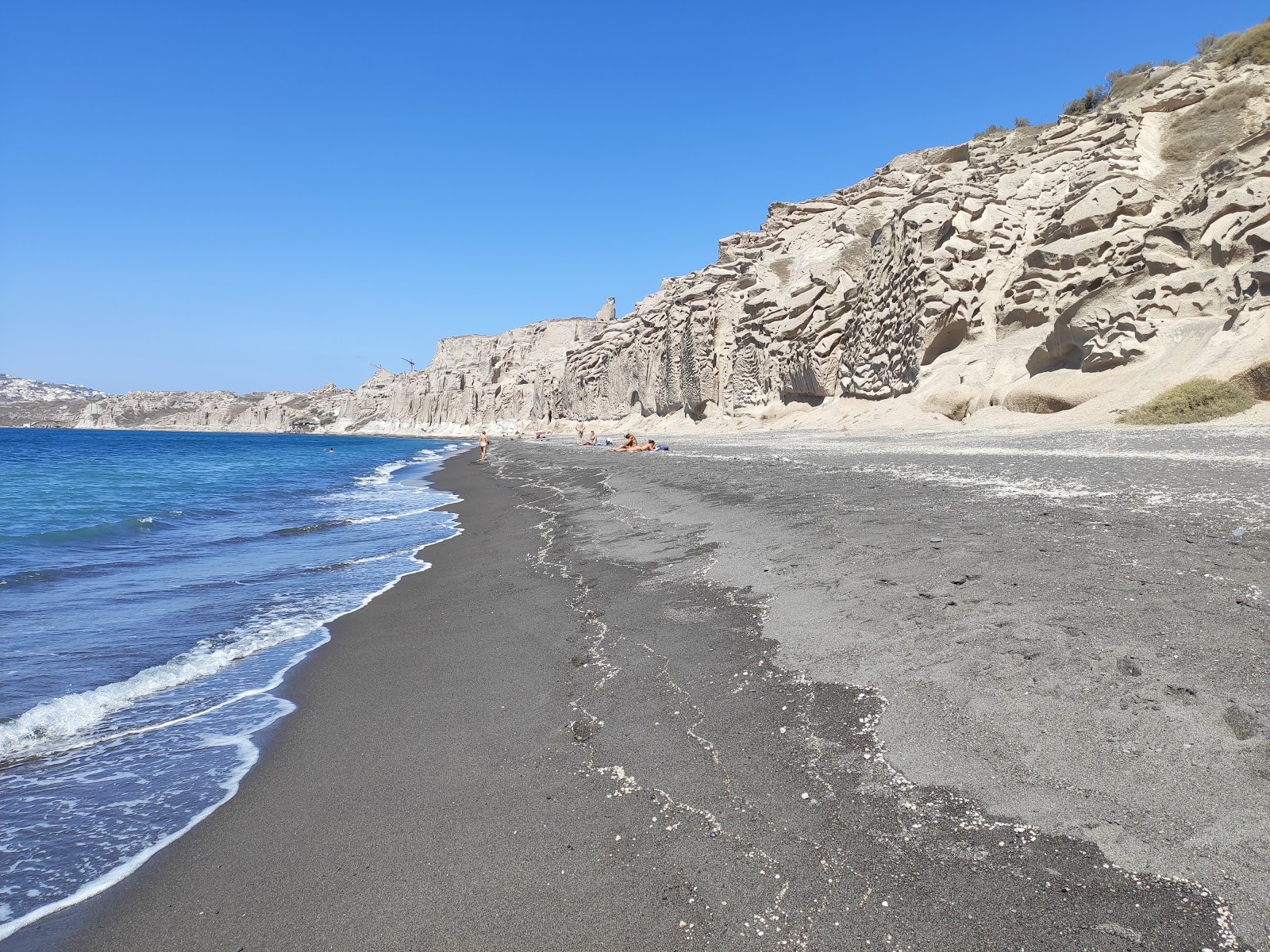 Foto av Paralia Vlichada med harmaa hiekka ja kivi yta