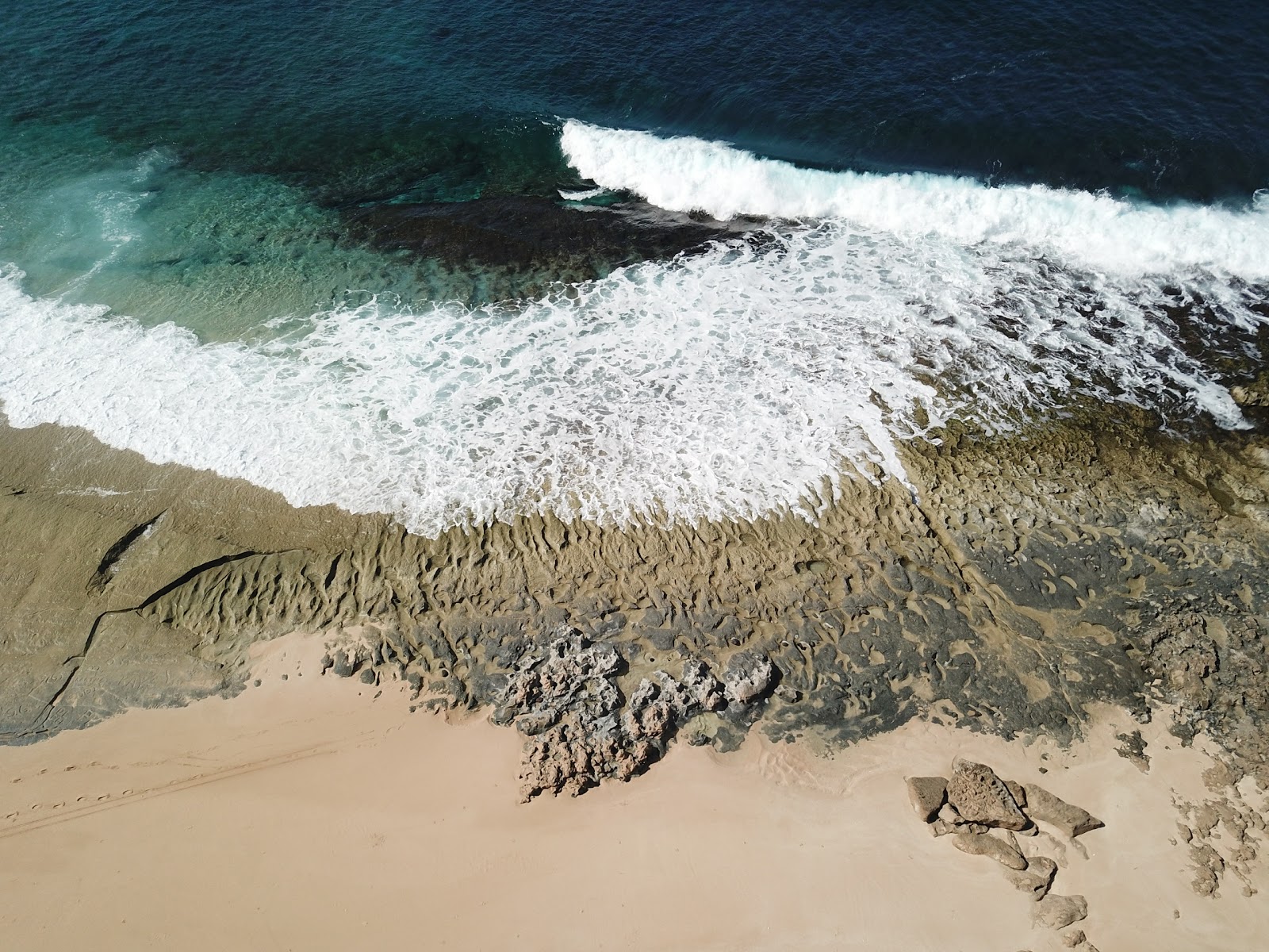 Foto av Ohiki-lolo Beach omgiven av klippor