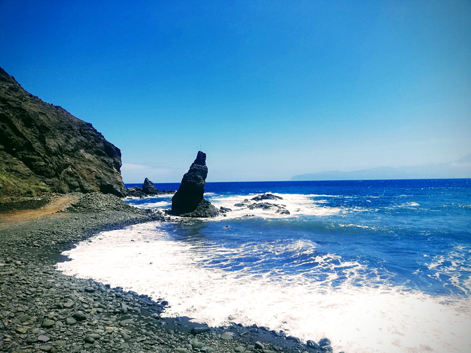 Foto av Playa de la Caleta omgiven av berg