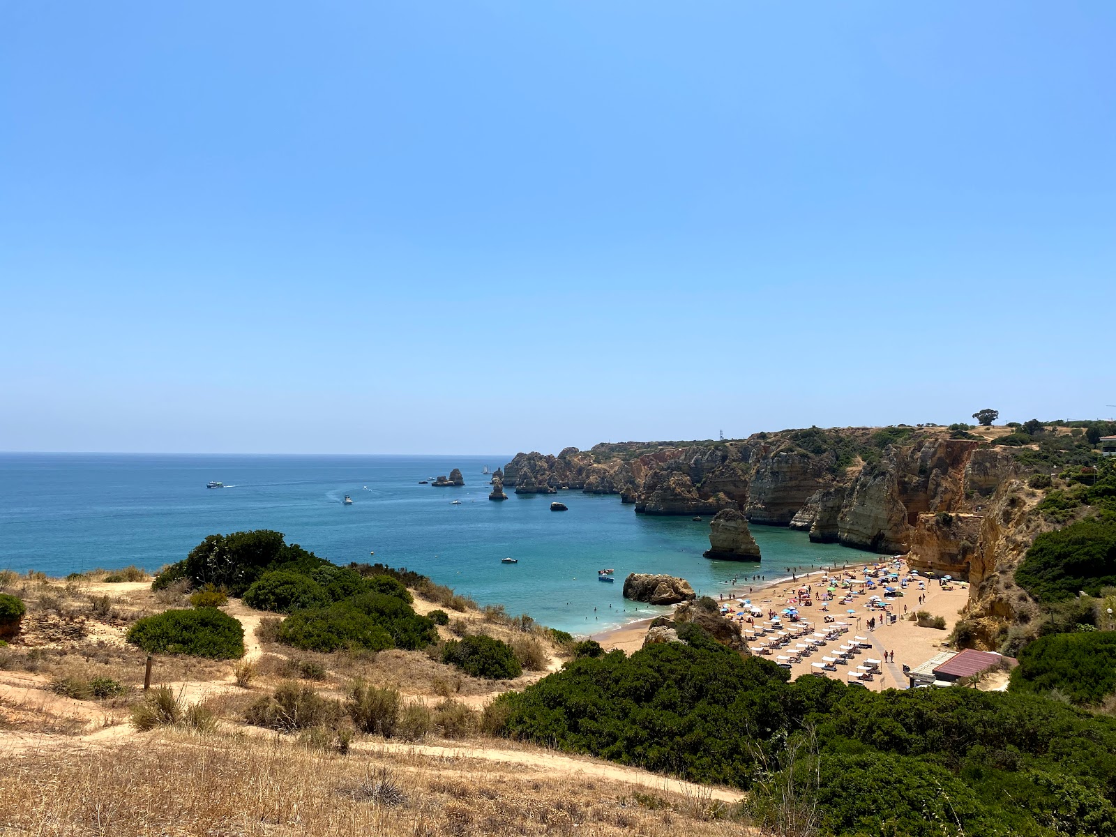 Foto di Praia de Dona Ana con una superficie del sabbia pura scura