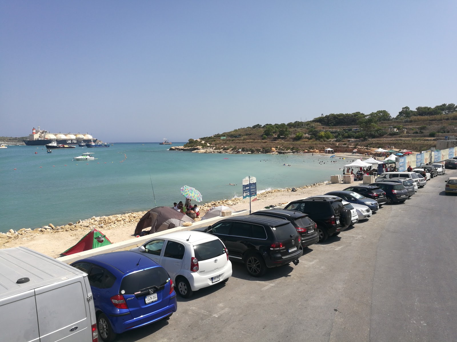 Zdjęcie Għar Aħmar Bay z powierzchnią beżowy piasek i kamienie