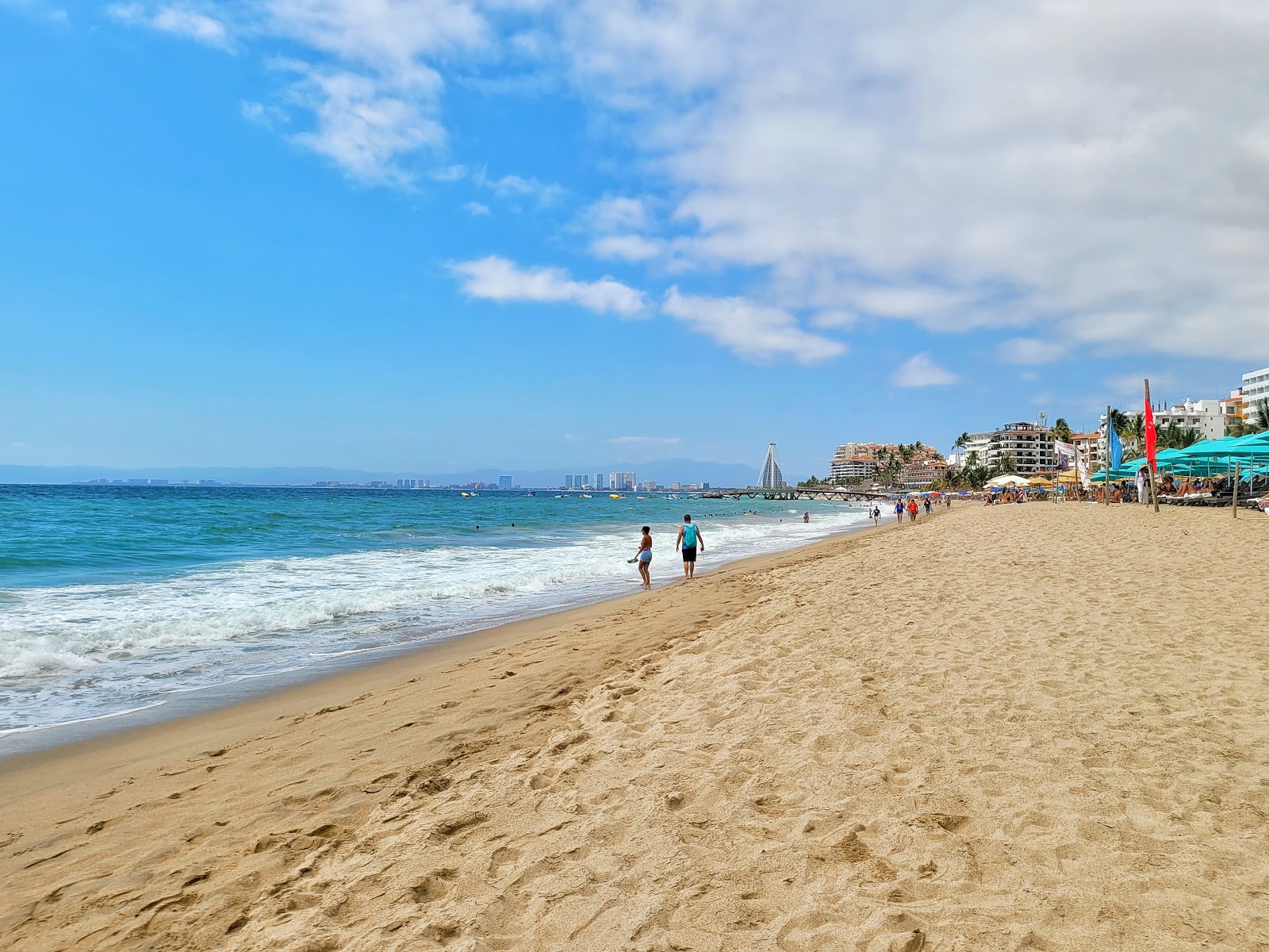 Foto de Los Muertos beach con brillante arena fina superficie