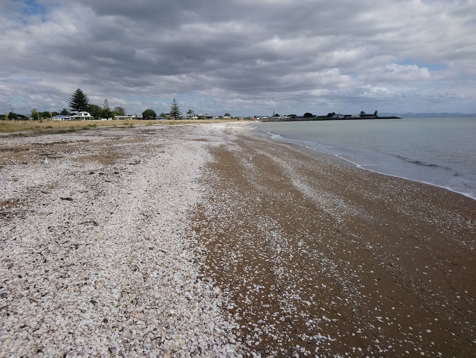 Foto av Kuranui Bay med lätt fin sten yta