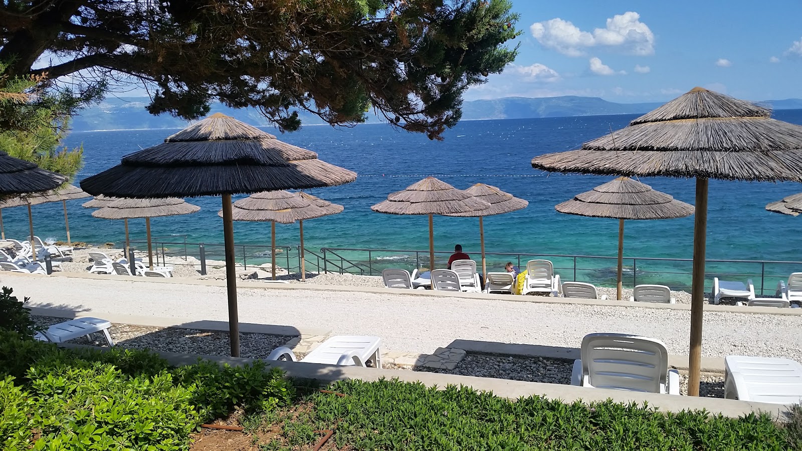 Foto af Maslinica beach bakket op af klipperne