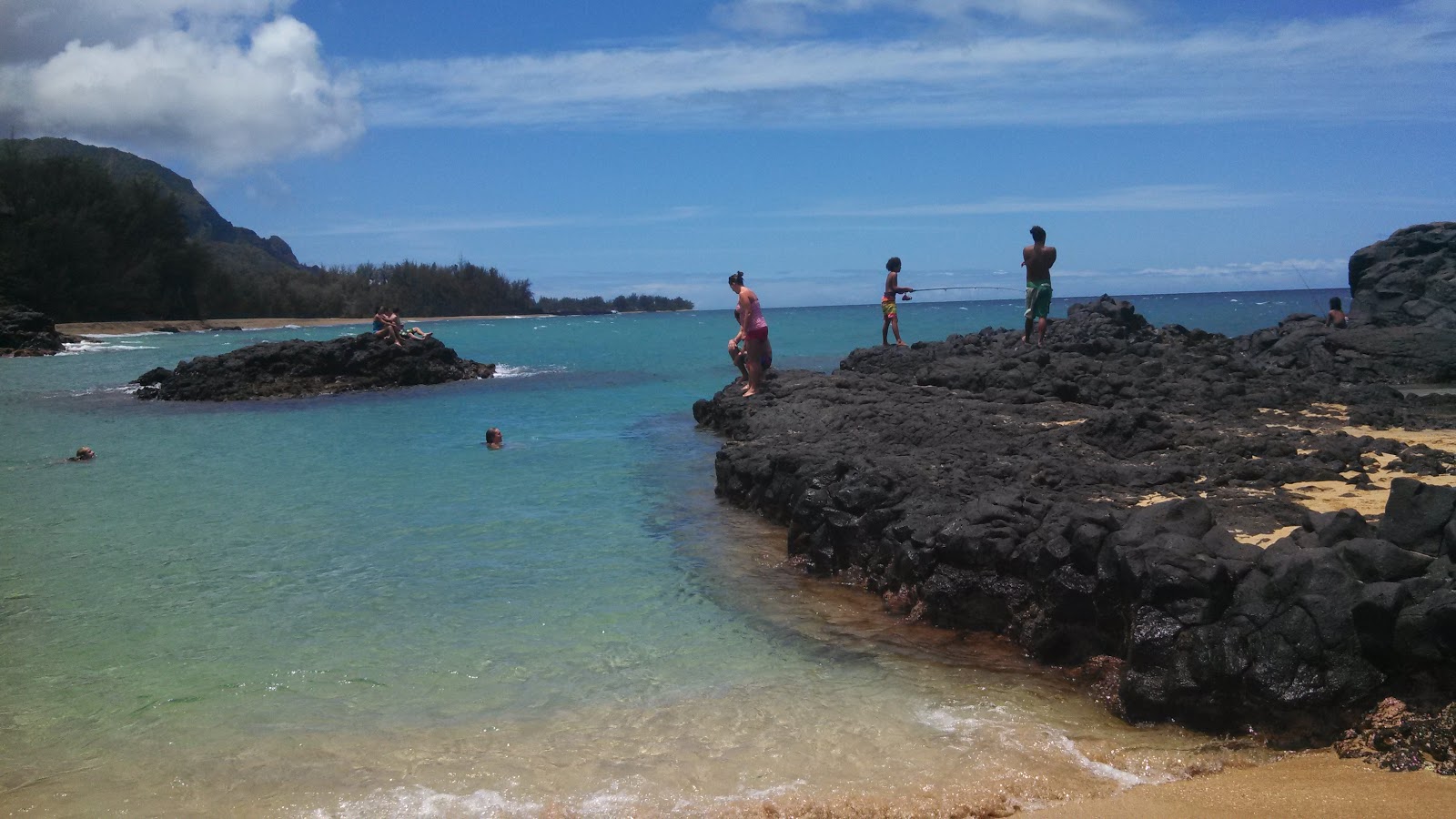 Foto af Lumaha'i Beach bakket op af klipperne