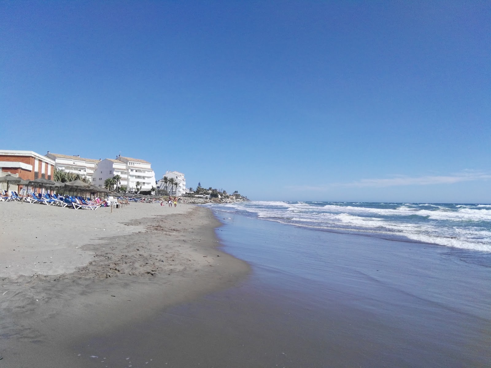 Foto di Playa de las Chapas con una superficie del sabbia grigia