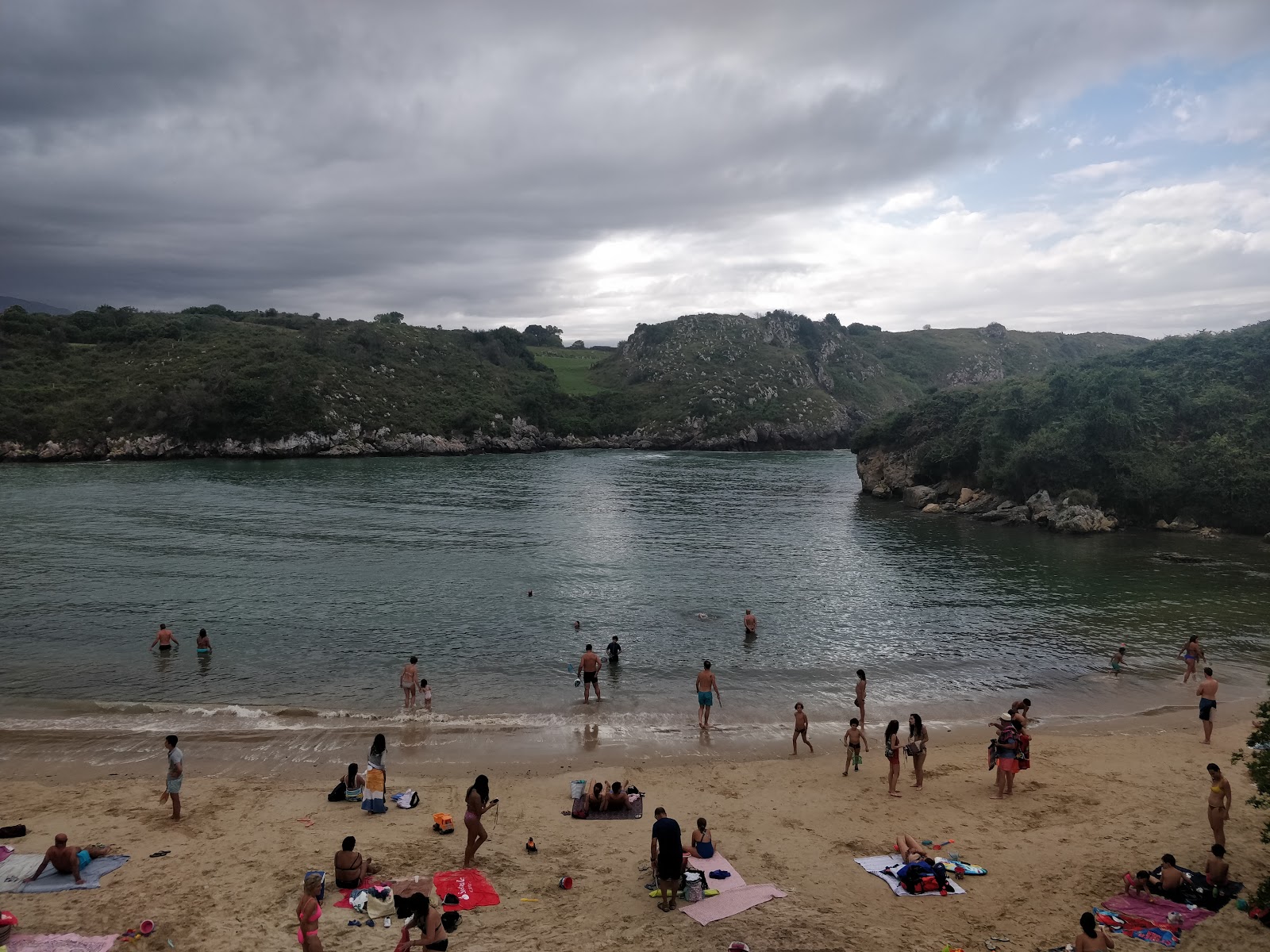 Foto av Poo Strand omgiven av berg