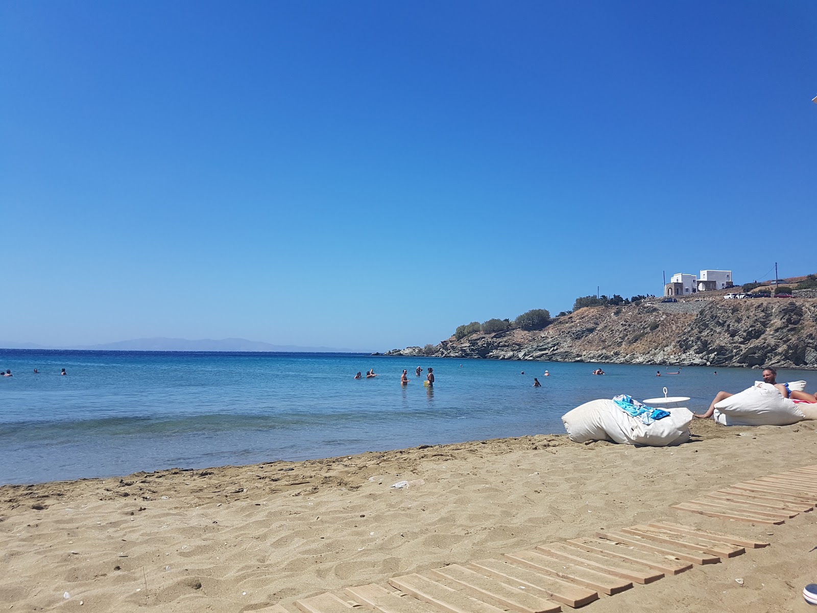 Agios Romanos Plajı'in fotoğrafı uçurumlarla desteklenmiş