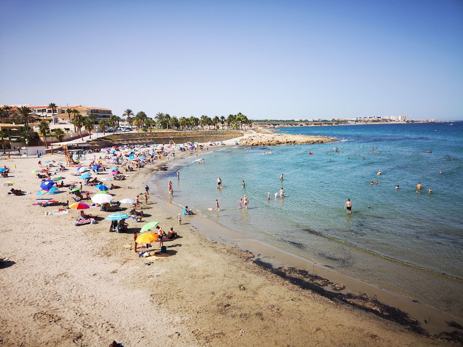 Foto van Flamenca Beach met blauw water oppervlakte