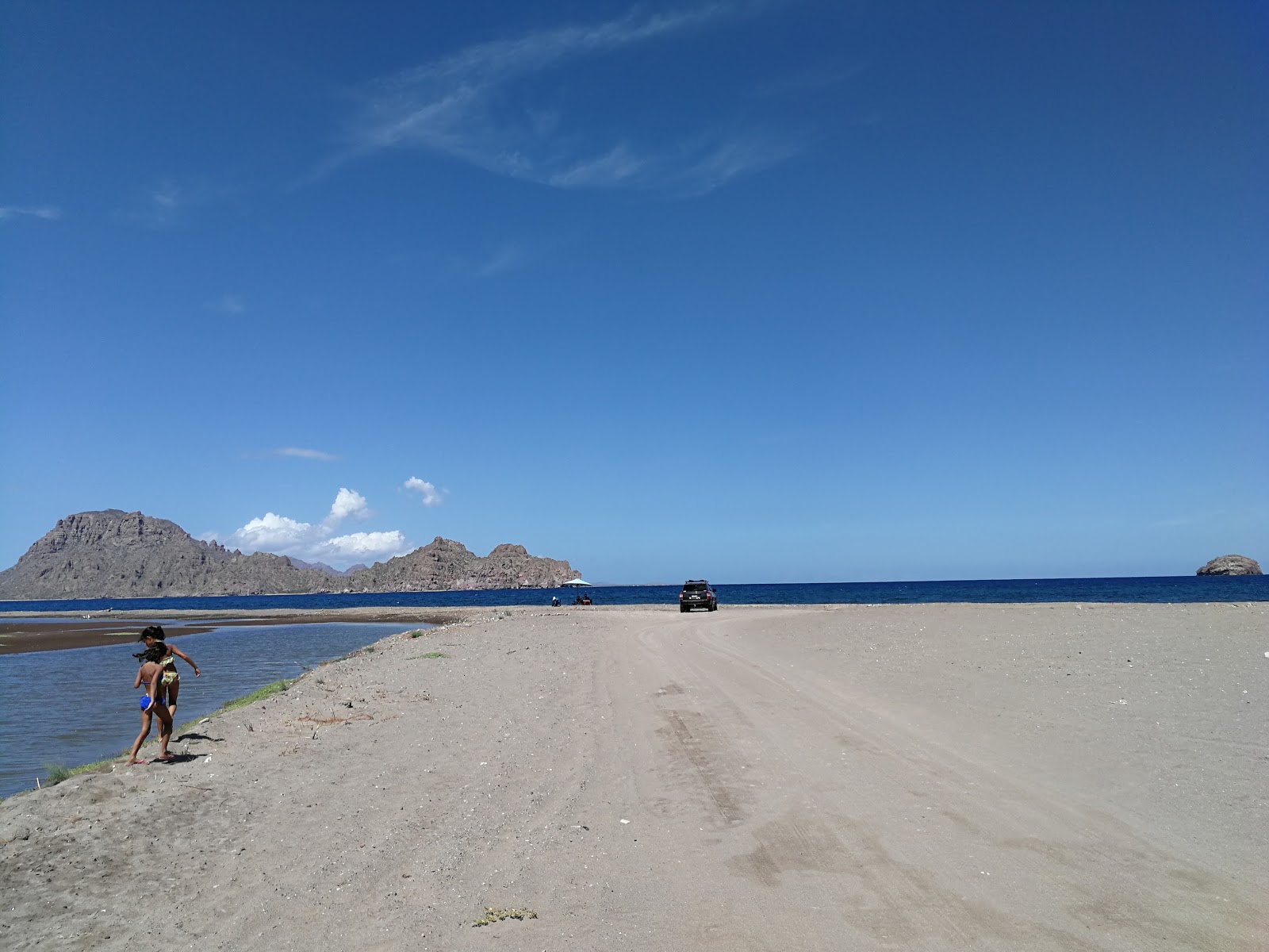 Valokuva Playa Liguiista. pinnalla harmaa hiekka ja kivi:n kanssa