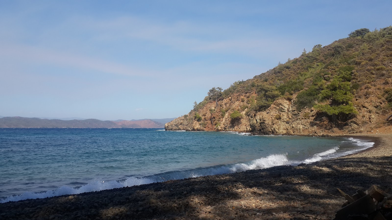 Fotografie cu Emesik Wild beach VIII cu o suprafață de pietricel maro